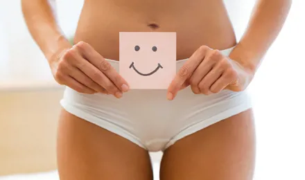 Femme en culotte blanche tenant un papier avec un smiley souriant dessus