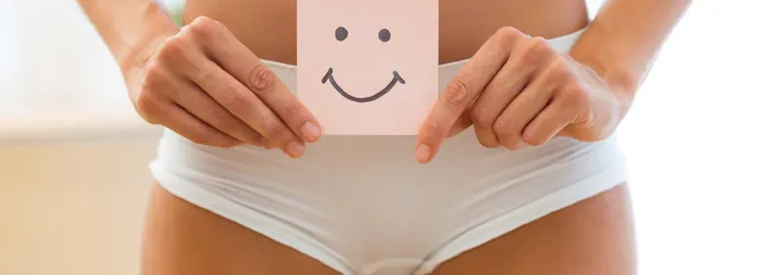 Femme en culotte blanche tenant un papier avec un smiley souriant dessus