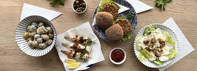Nuori perhe nauttii grillauksesta puutarhassa aurinkoisena päivänä