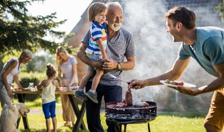Mies valmistelee grillijuhlia perheen takapihalla