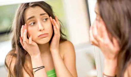 Un adolescent vérifie ses yeux gonflés par les allergies dans le miroir