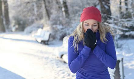 Une jeune femme court dans la neige avec un rhume et veut savoir comment traiter une allergie au pollen avec un remède maison