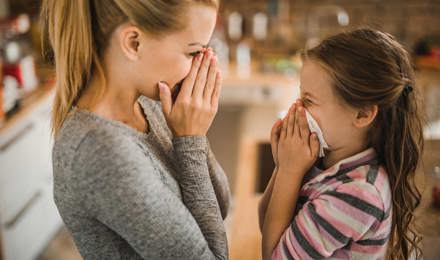 Äiti näyttää tyttärelleen, kuinka nenäverenvuoto pysäytetään