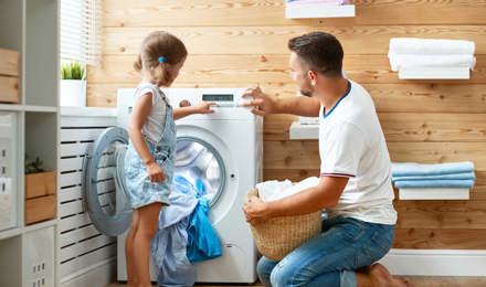 Père et fille font la lessive ensemble et passent un moment amusant