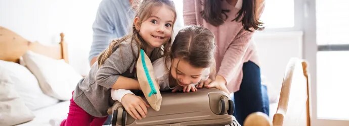 Parents et leurs deux filles faisant une valise